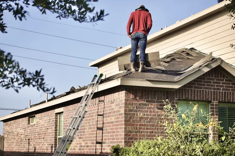 Professional roofer working on a residential roof in Prathertown